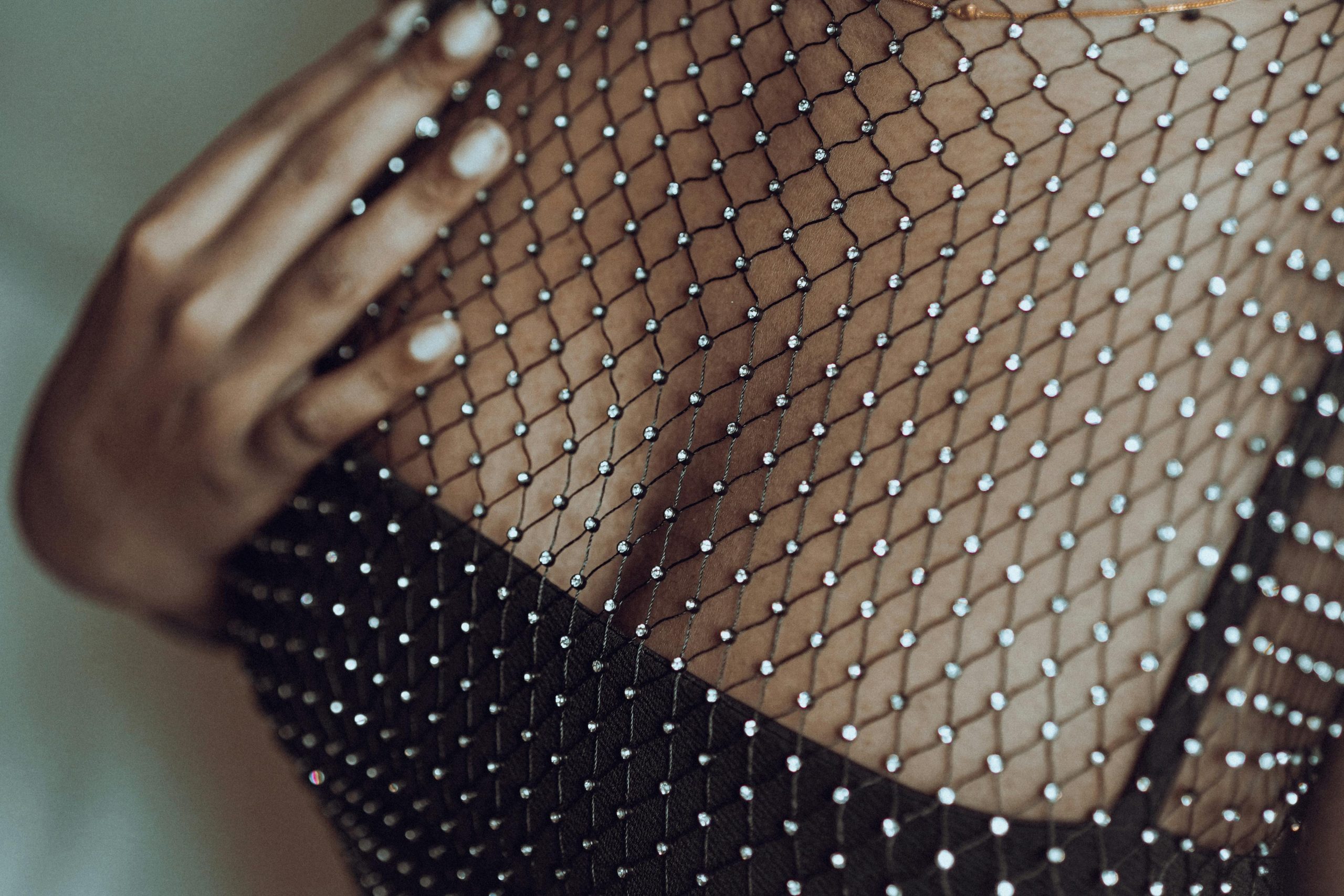 Close-up of a stylish mesh dress adorned with rhinestones, showcasing intricate detail and fashion elegance.